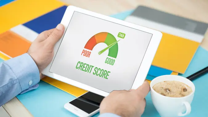 Man looking at his smart tablet showing his god credit score