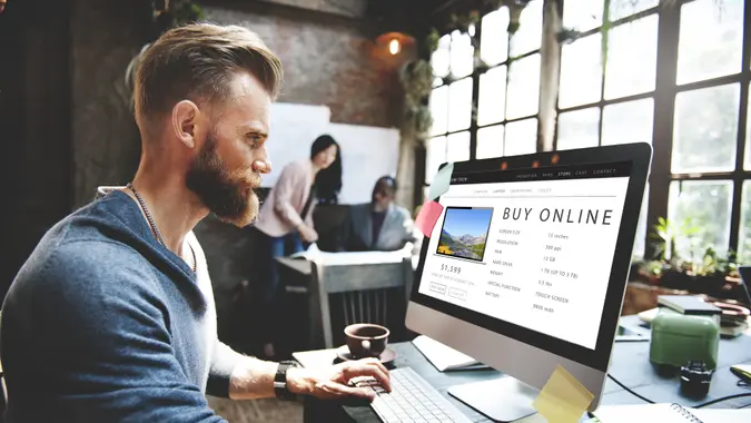 man at coffee shop buying computer online