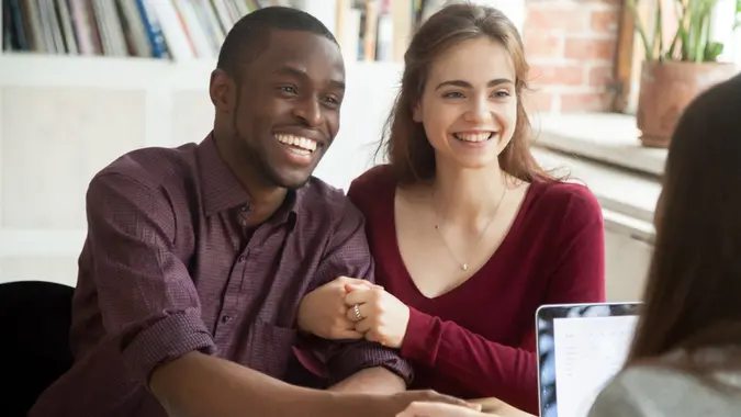 couple customers shaking hands with mortgage broker or financial advisor