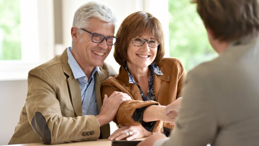 Senior couple meeting financial adviser for investment.