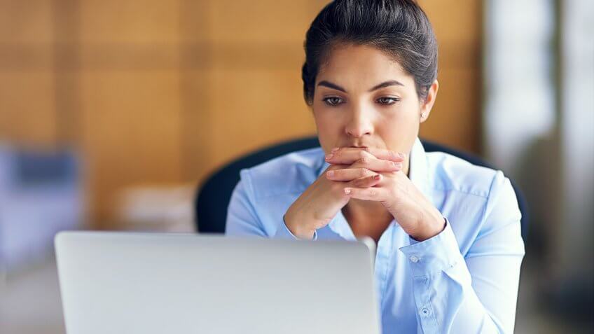 Shot of a young businesswoman looking stressed while working at her desk