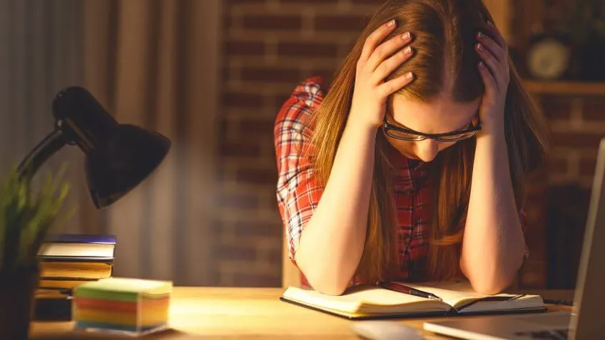 woman looking frustrated at her notebook