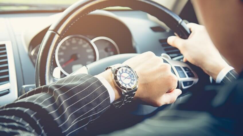 man driving looking at his fancy watch