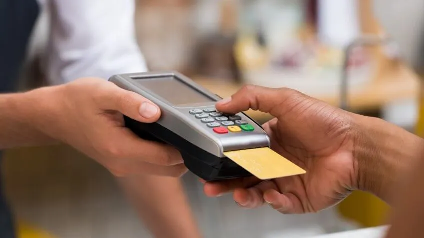 Close up of person paying with their credit card