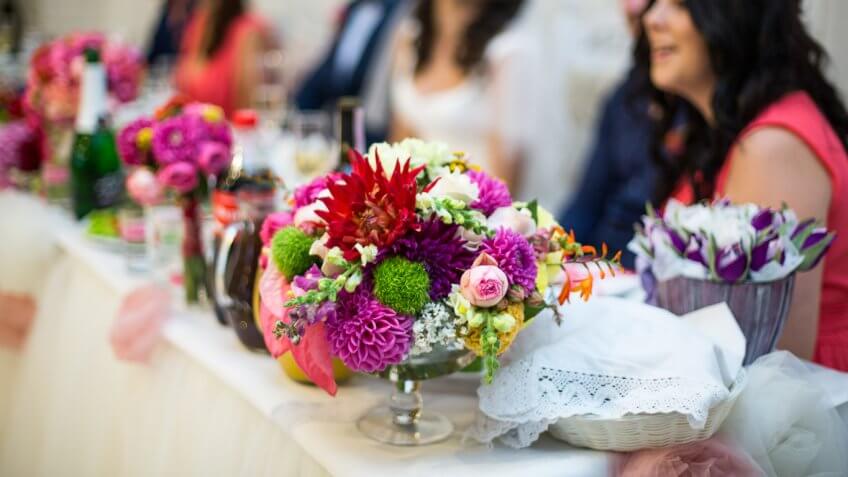 group of people sitting table with floral arrangements