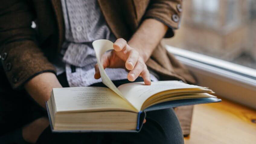 man flipping a page in his book