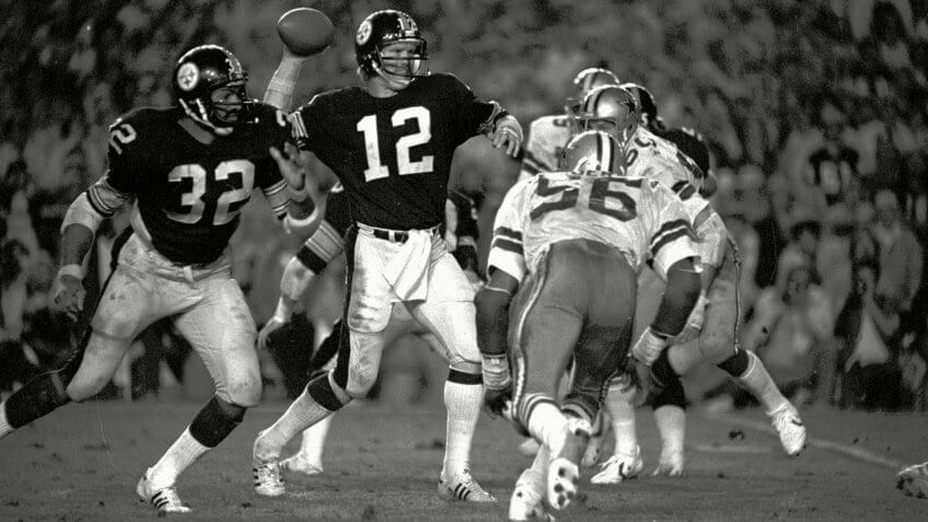 BRADSHAW HARRIS HENDERSON Pittsburgh Steelers quarterback Terry Bradshaw winds up to fire a pass during Super Bowl XIII against the Dallas Cowboys in Miami .