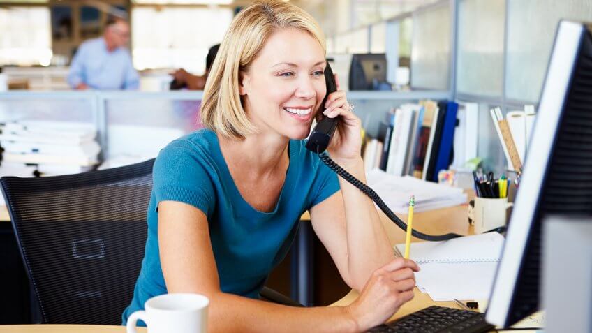 smiling woman on phone at work