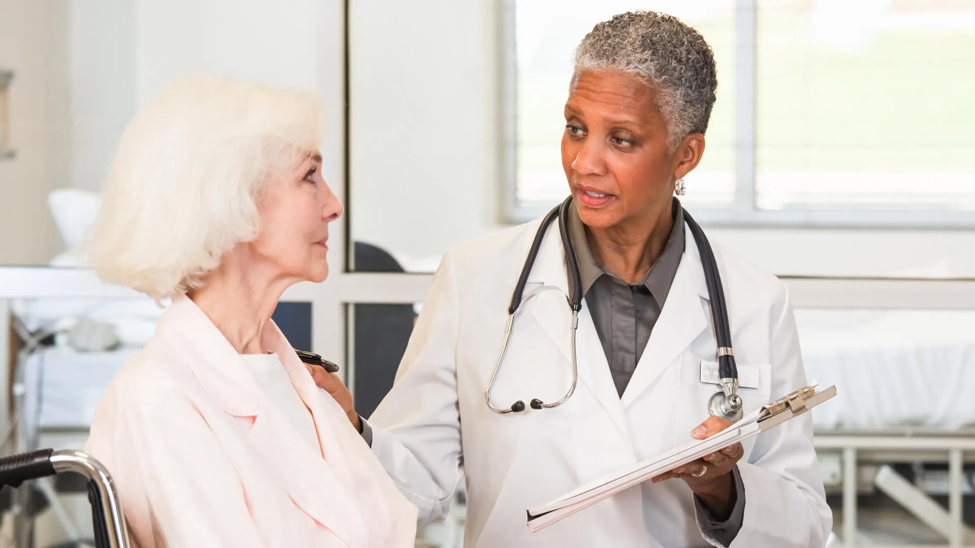 Doctor talking to patient in wheelchair