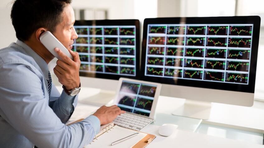man on a phone looking at the stock market
