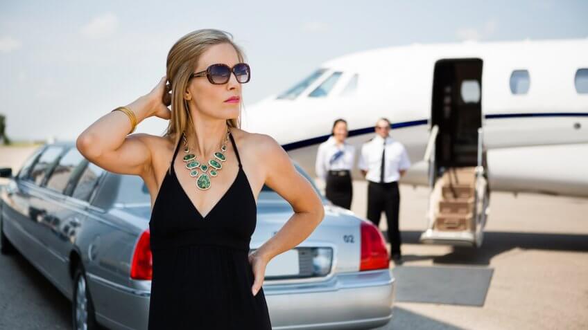 woman outside of a limo and private plane
