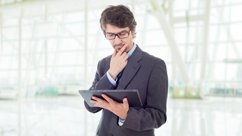 man looking inquisitively at his tablet