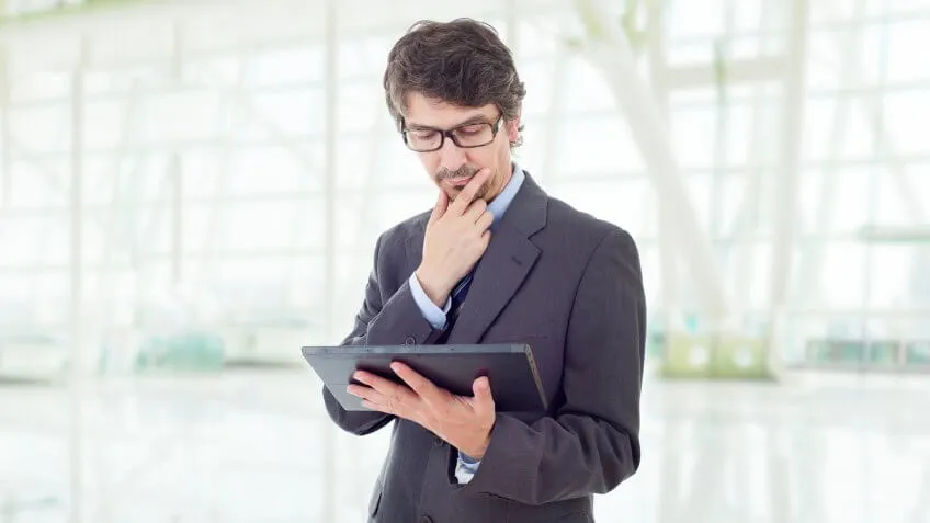 man looking inquisitively at his tablet