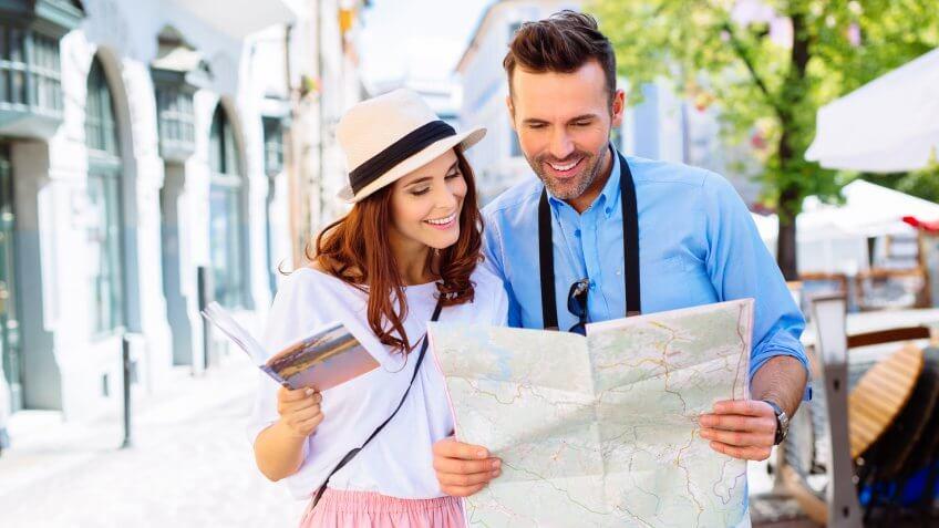 young couple traveling looking at map tourist