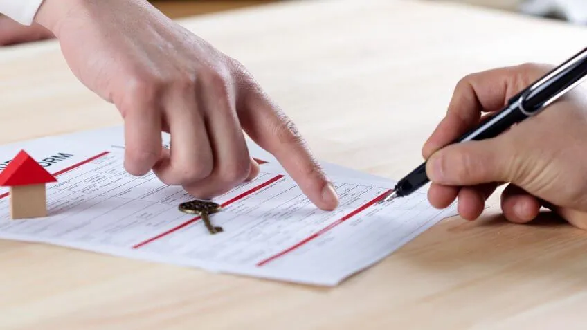 man signing papers for home