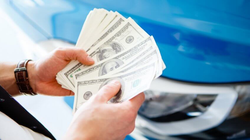 man fanning and counting $100 cash money