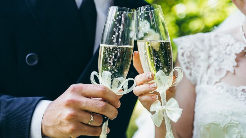 bride and groom clinking glass of champagne