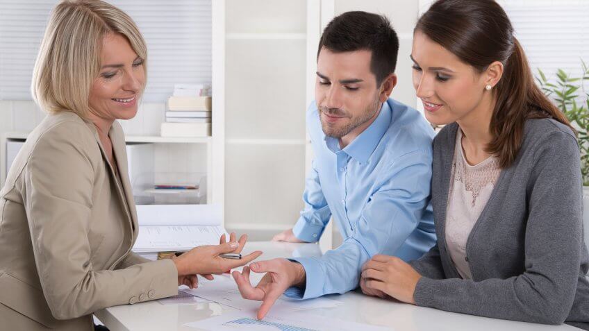 young man and woman reviewing documents with an adviser
