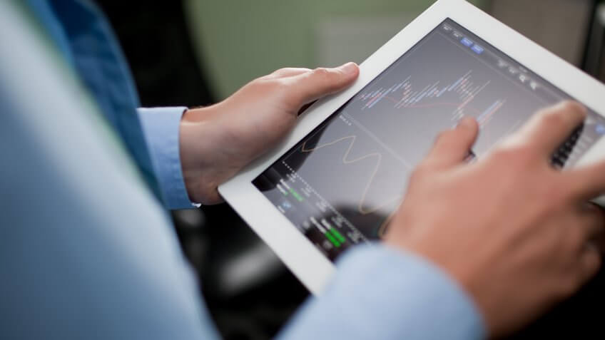 man looking at stocks on his ipad tablet