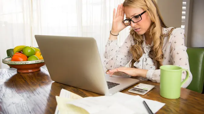 woman looking frustrated at her laptop