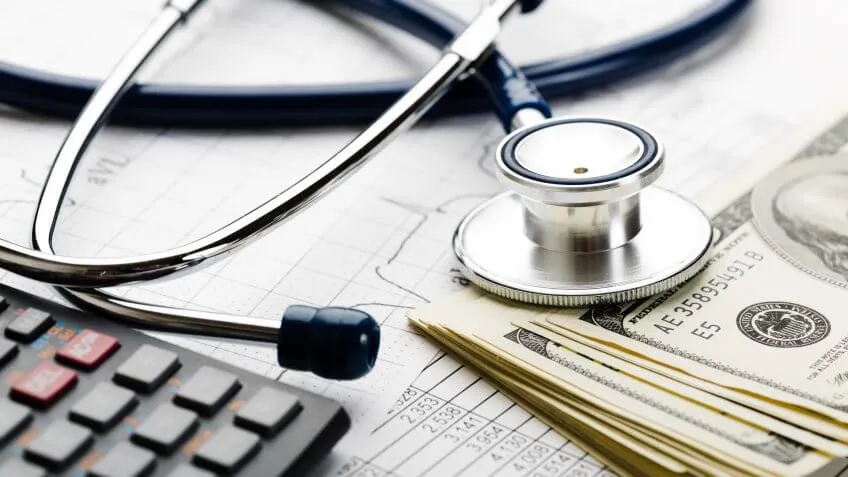 stethoscope over a calculator and pile of money