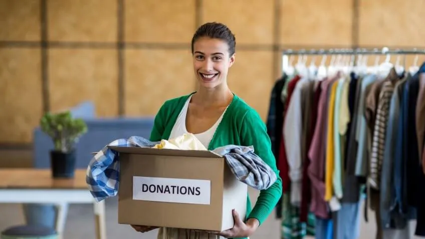 woman holding a box of clothing donations