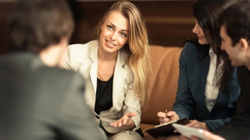 Woman speaking to circle of other coworkers