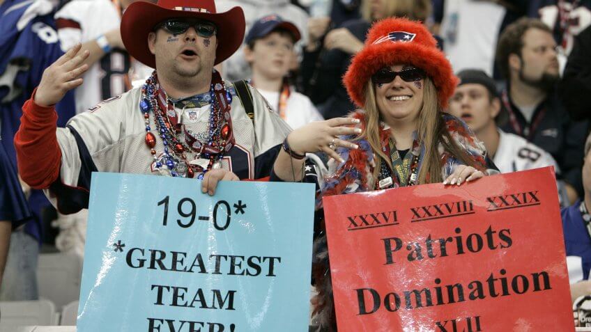 New England Patriots fans hold up signs and four fingers before the Super Bowl XLII football game between the Patriots and the New York Giants at University of Phoenix Stadium, in Glendale, Ariz.