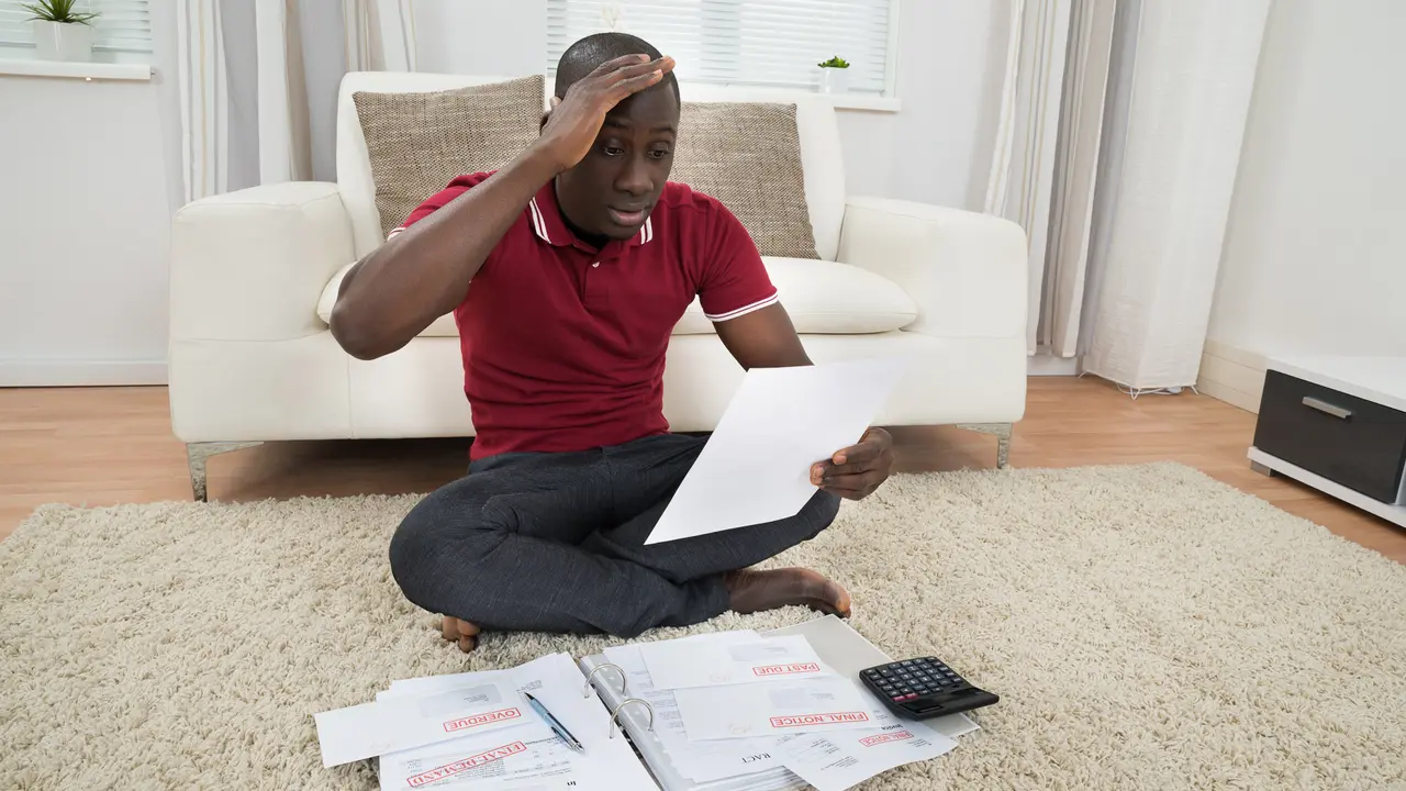 man looking frustrated as he loks at his documents papers