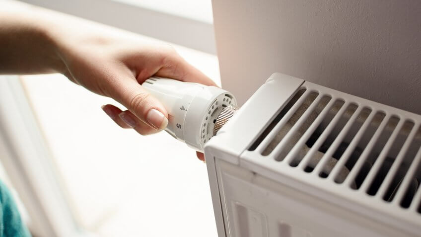 person fixing thermostat