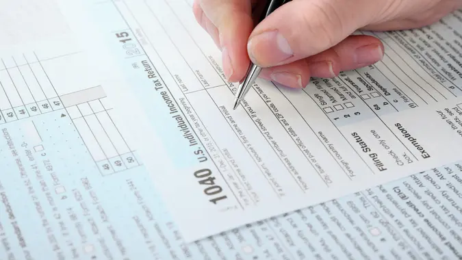 person filling out their 1040 individual income tax return form