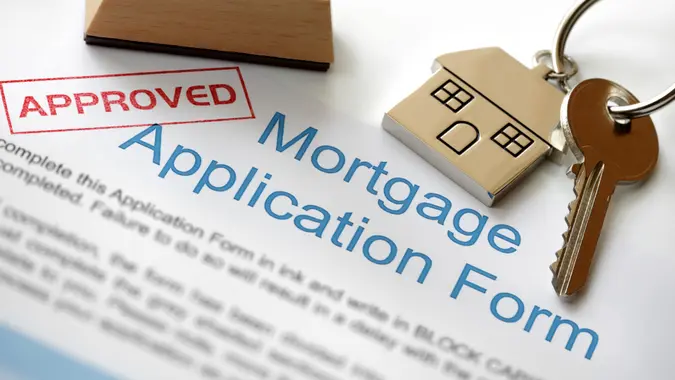 Approved Mortgage loan application with house key and rubber stamp.