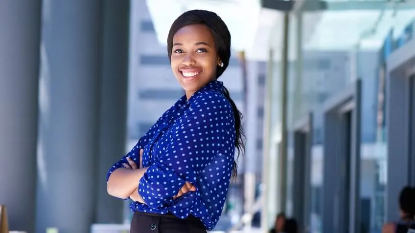 woman smiling in front of a business building