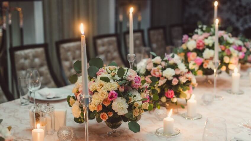 floral arrangements and candles on a wedding dining table