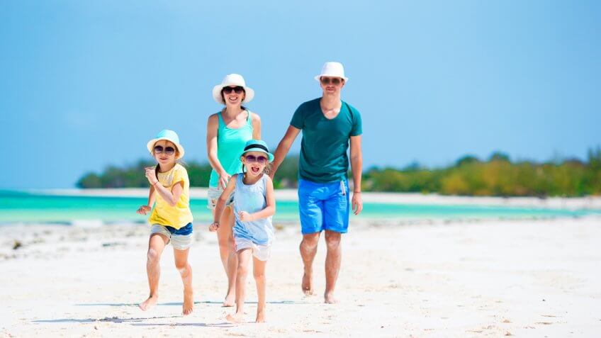 family vacationing playing on the beach