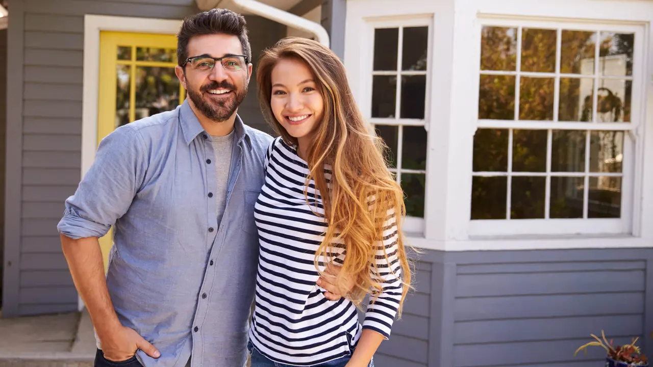 Couple Standing Outside New Home