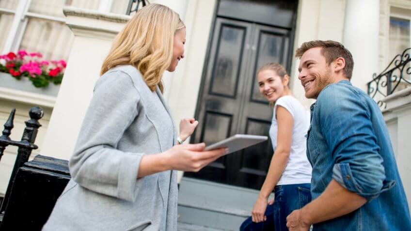 Couple buying a house with a real estate agent.