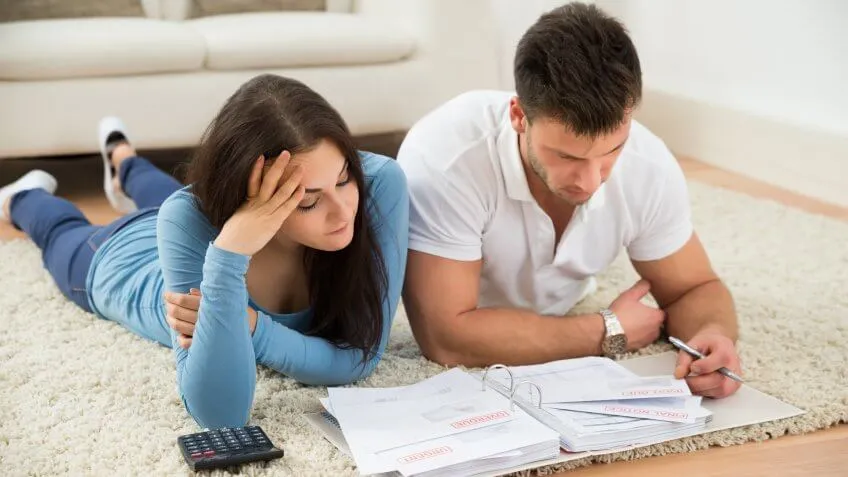 young couple laying on the floor doing paperwork