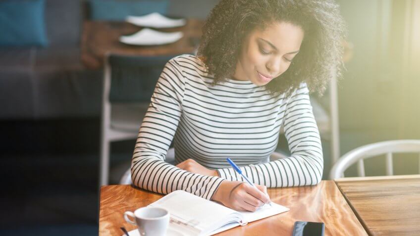 woman journaling in a coffee shop