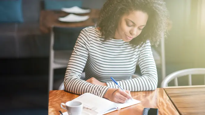 woman journaling in a coffee shop