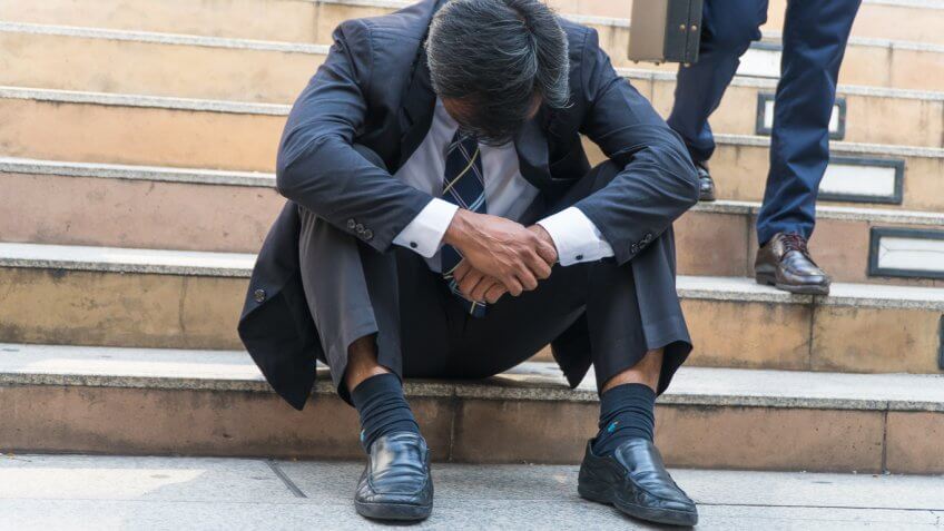 man sitting at the bottom of stairs sadly