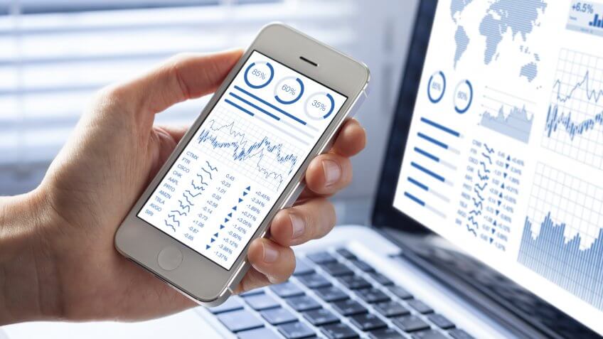stocks on a smartphone and laptop screen