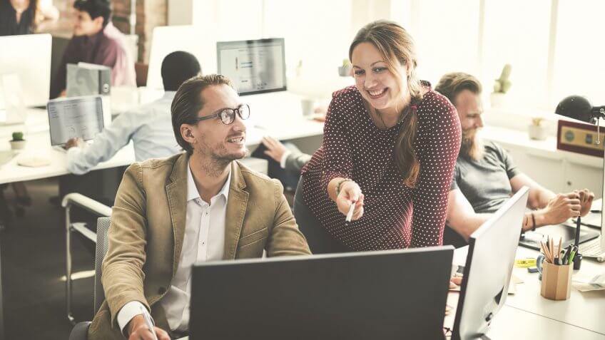 woman pointing to a computer with a man