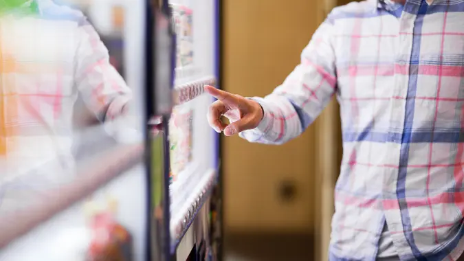 A person checking his options before choosing a snack at a vending machine in Kansas.