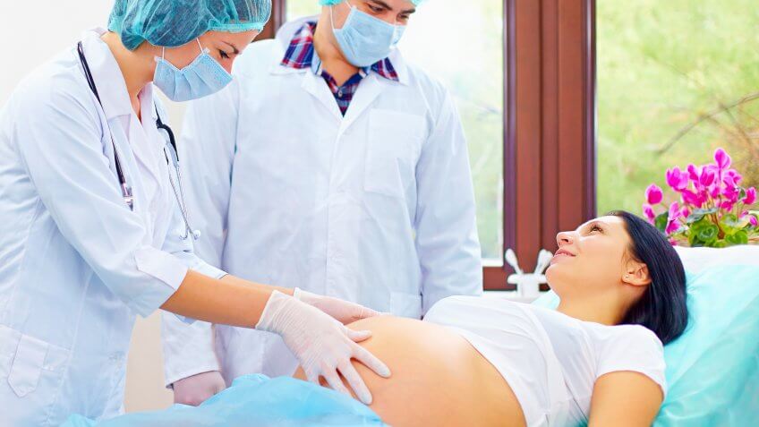 doctors checking pregnant woman