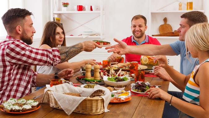 friends family at the dining table passing food around