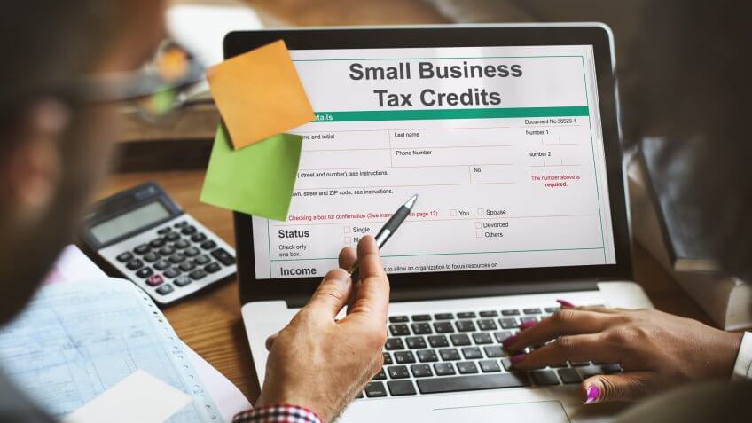 couple looking up small business tax credits on laptop