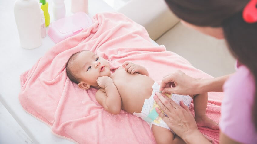 woman changing a baby's diaper