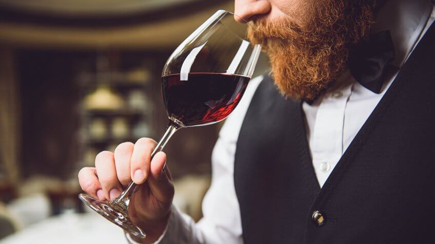 fancy man sniffing glass of wine