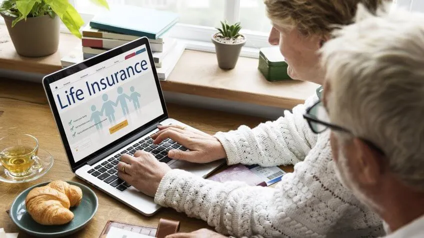 old couple looking up life insurance on the computer